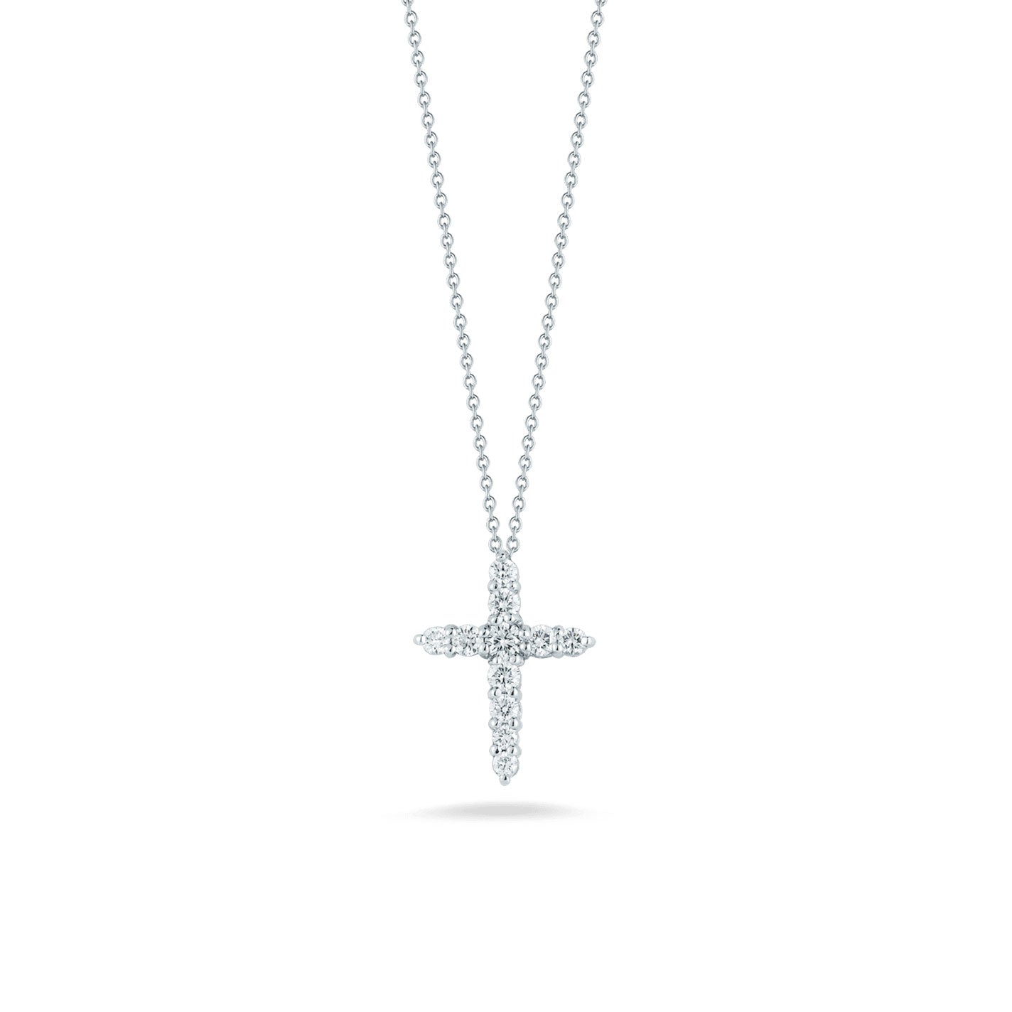 The Roberto Coin Tiny Treasures 18K White Gold Diamond Cross Necklace Pendant is highlighted on a plain white background, featuring a cross-shaped charm in white gold adorned with small sparkling diamonds, showcasing the brand's signature delicate design.