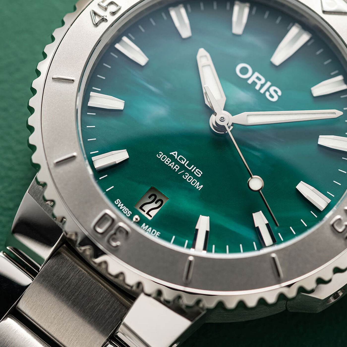 The Oris Aquis X Bracenet Automatic 43.5mm Watch by ORIS features a captivating green dial accented with luminescent hands. It includes a stainless steel bezel with minute markers and conveniently shows the date at the 6 o'clock position, all designed to endure depths of up to 30BAR/300M.