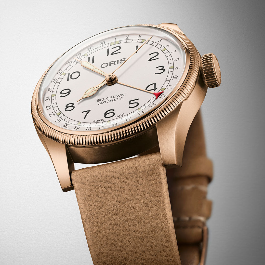 A close-up view of the Oris Big Crown Father Time Limited Edition Automatic Winding 40mm Watch captures attention with its gold-toned case and beige leather strap. The white dial, featuring black numerals, prominently showcases the "ORIS" brand along with "Big Crown Automatic." A red second hand introduces a vibrant touch to this exquisite timepiece.
