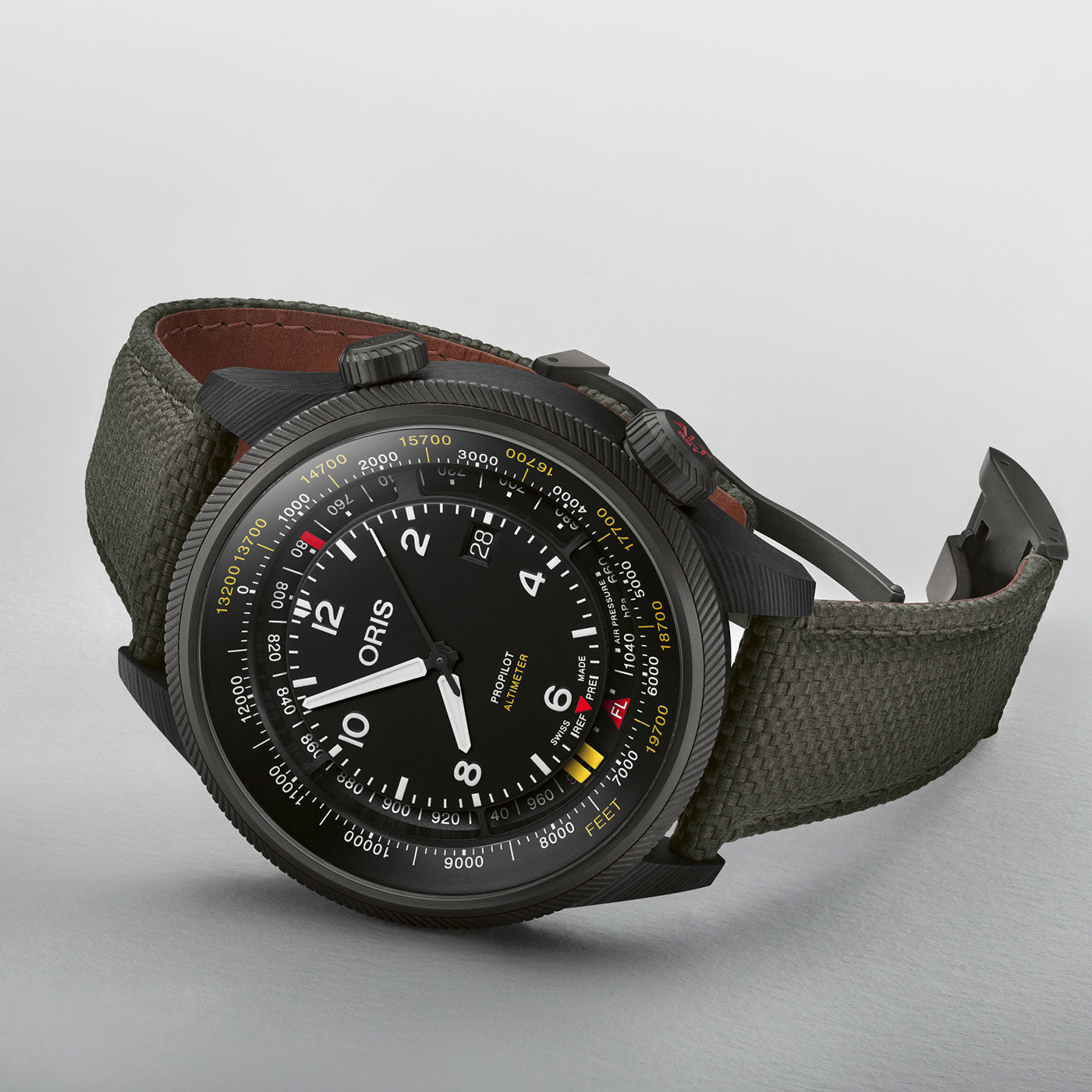 The Oris Propilot Altimeter Automatic 47mm watch features a black case and bezel, a stylish dial with numbers, markings, and "ORIS" branding. Its sleek hands complement the dark fabric textured strap for a sophisticated look.