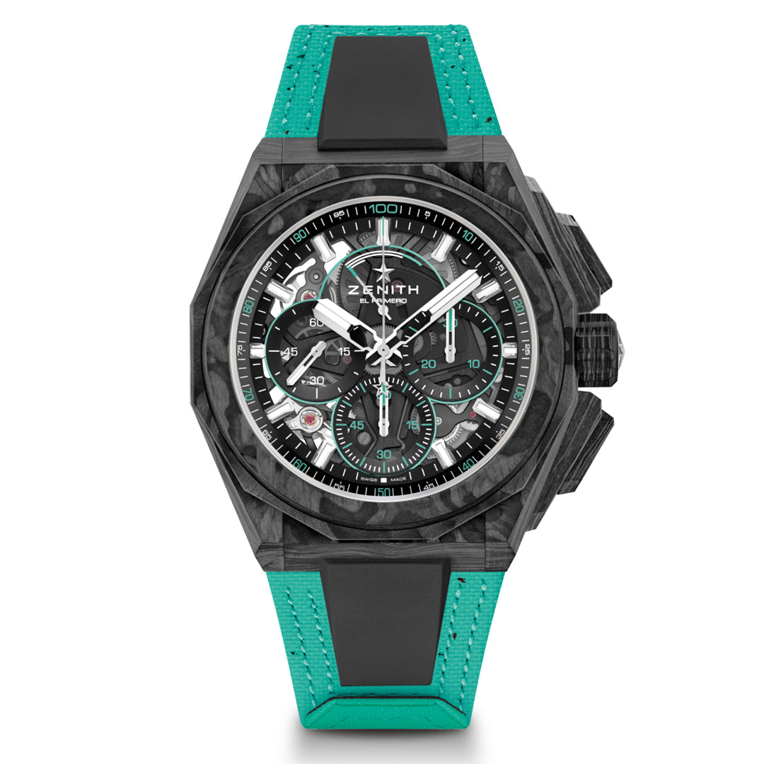 The Zenith Defy Extreme El Primero 9004 features a textured black case and teal strap. Its face showcases multiple dials with white numerals, hands, and a small red accent near the bottom, along with the brand name "Zenith" visible on it.