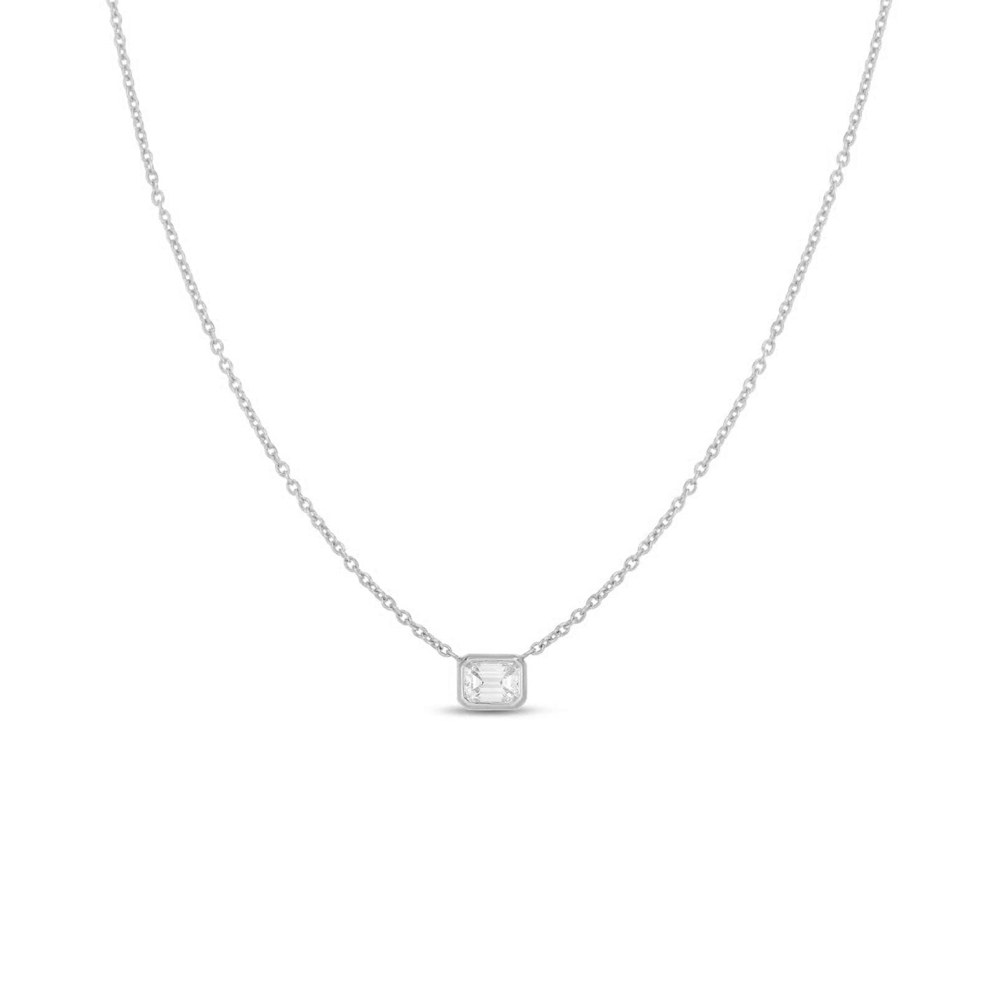 The Roberto Coin Diamonds By The Inch 18K White Gold Emerald Cut Diamond Necklace Pendant showcases elegance with its delicate silver chain and small rectangular pendant adorned by an emerald-cut diamond. Its minimalist design stands out beautifully against a plain white background, embodying Roberto Coin's signature style.