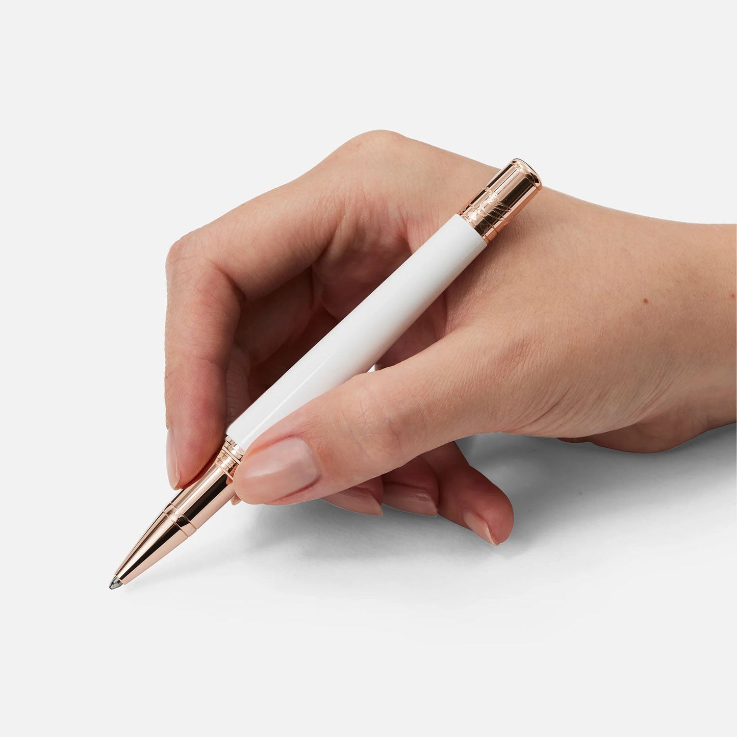 A hand, reminiscent of a style icon, holds the Montblanc Muses Marilyn Monroe Special Edition Pearl Rollerball Pen against a plain background.