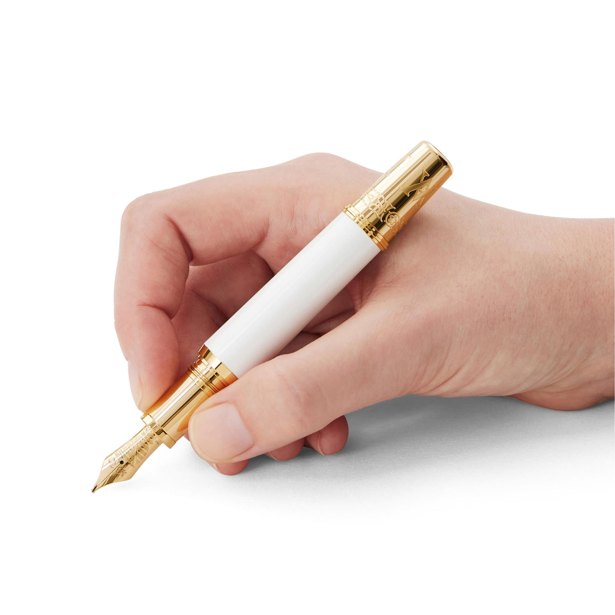 A hand delicately holding a Montblanc Patron of Art Homage to Albert Limited Edition 4810 Fountain Pen, with its elegant white and gold design, hovers gracefully above a pristine surface.