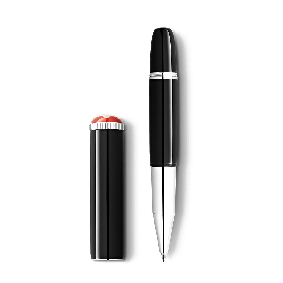 The Montblanc Heritage Rouge et Noir Baby Special Edition Black Rollerball Pen stands elegantly against a plain white background. Its sleek black body, featuring a silver grip and tip, is displayed vertically next to its matching black cap adorned with the distinctive red and white top. This exquisite piece exemplifies timeless design.