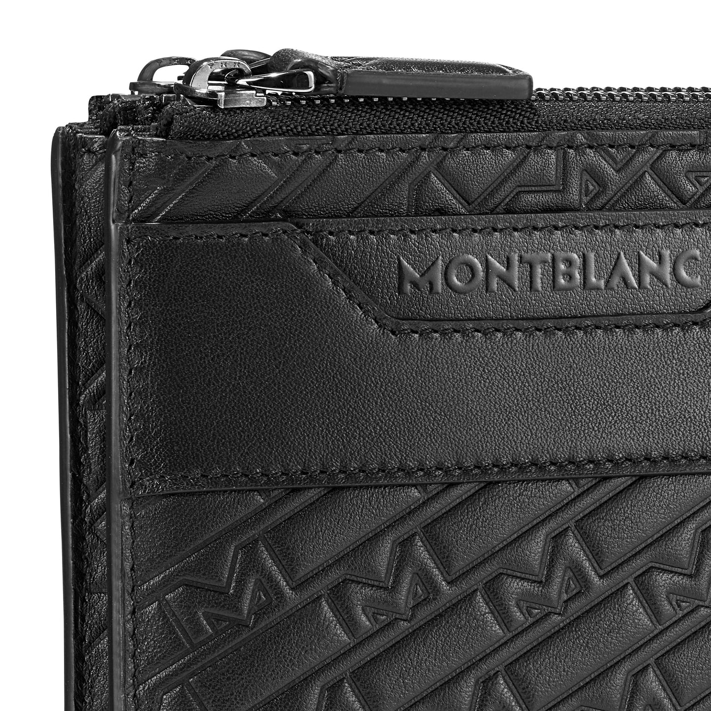 Close-up of a black leather Montblanc M-Gram Leather Clutch Bag adorned with an embossed geometric pattern and the Montblanc logo. This stylish clutch features a top zipper, highlighting its detailed craftsmanship and texture.