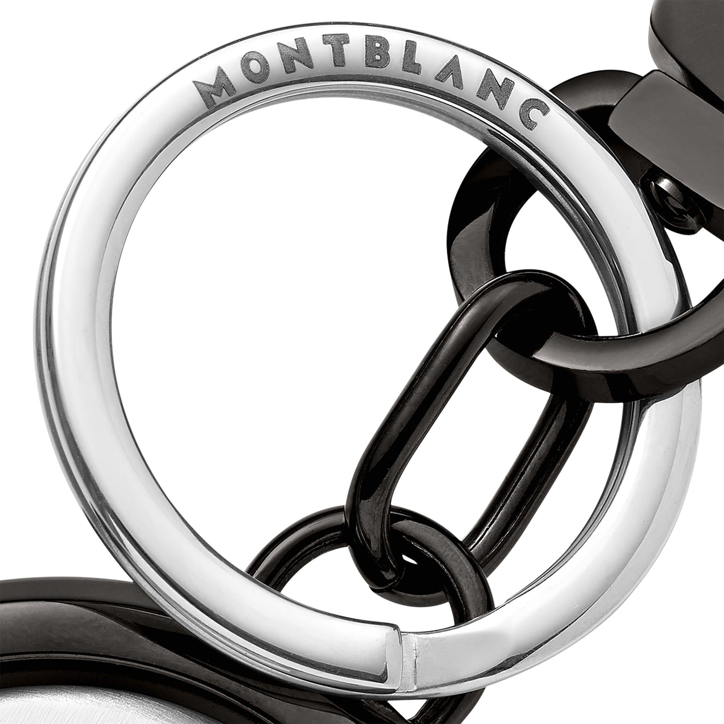 Close-up of a Montblanc Meisterstuck Spinning Emblem Key Fob, featuring a shiny silver circular ring engraved with the Montblanc name, connected to black rings. The design highlights a modern and elegant combination of silver and black elements centered around its spinning emblem.