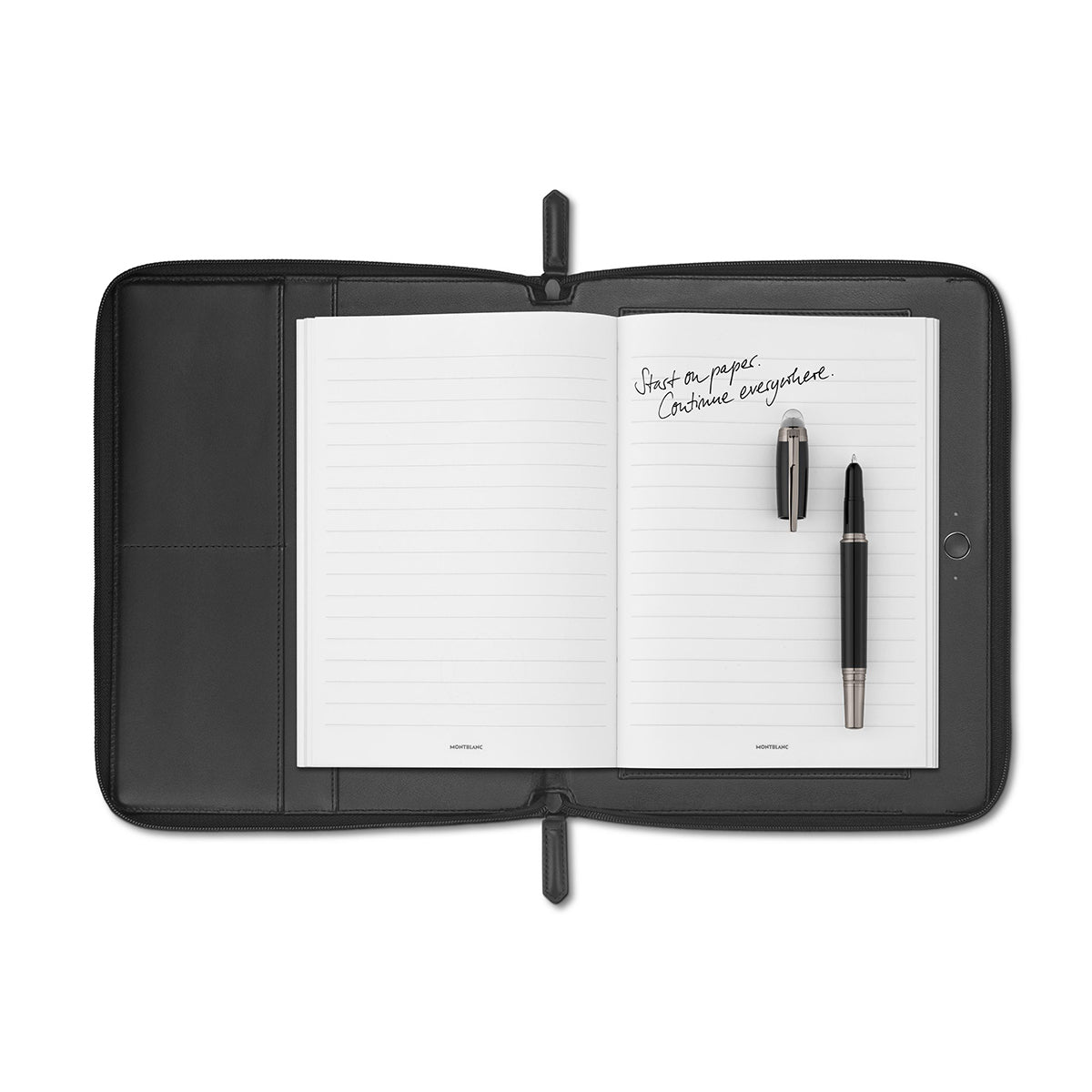 The open Montblanc Augmented Paper x Montblanc UltraBlack Edition notebook, featuring lined pages with handwritten text that reads "Just a paper. Continue everywhere," is elegantly set against a white background. On the right-hand page rests a pen and stylus from the Montblanc Set Augmented Paper collection.