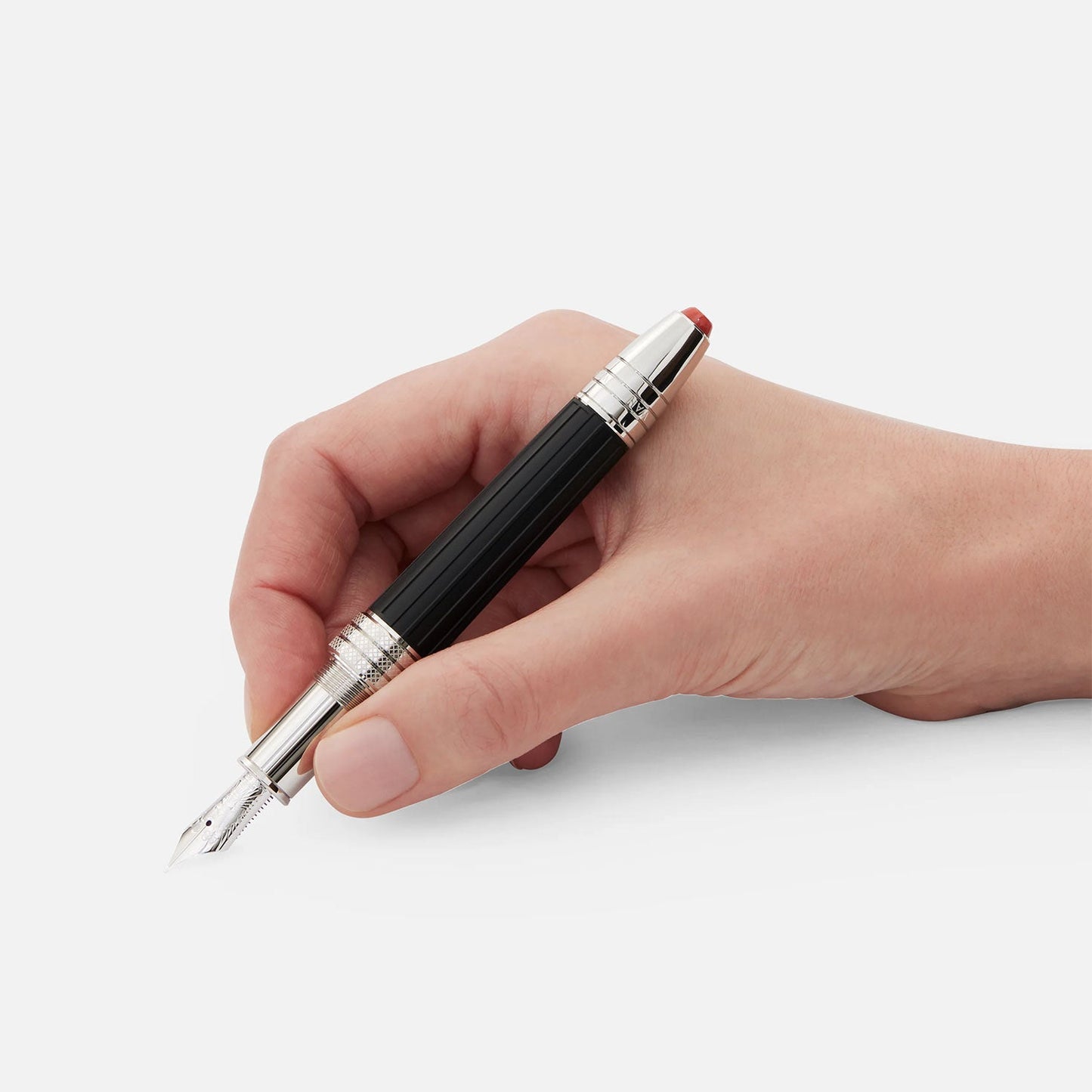 A hand holding a Montblanc Great Characters Jimi Hendrix Special Edition Fountain Pen, featuring a black and silver design with the nib and cap clearly visible, against a plain white background.