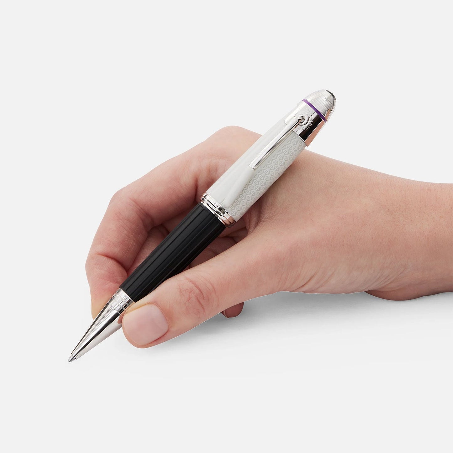 A hand grasping the Montblanc Great Characters Jimi Hendrix Special Edition Ballpoint Pen, featuring a luxurious black and silver body with a textured grip section reminiscent of an electric guitar's sleek finish. The background is plain white.
