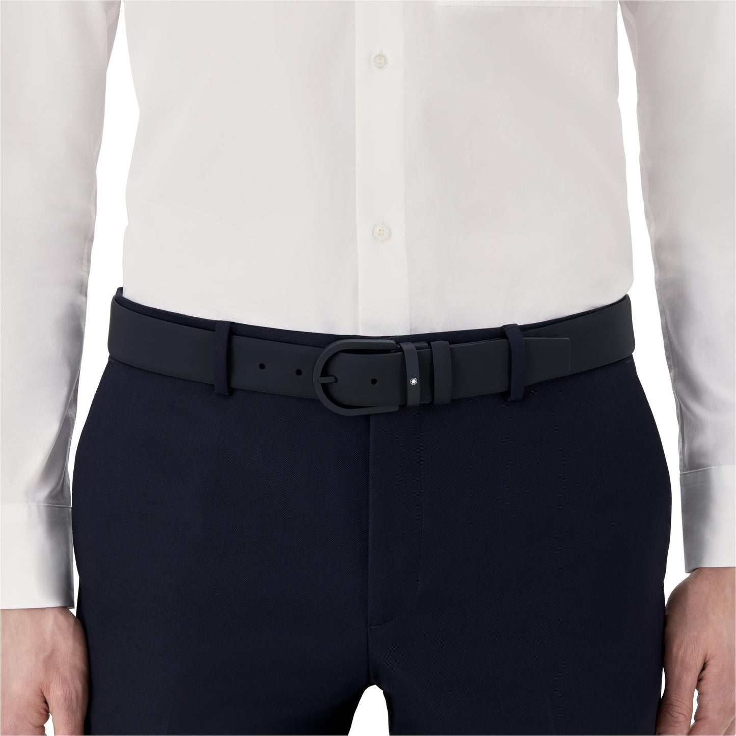 A person is wearing a white button-up shirt tucked into dark trousers, accentuated by the Montblanc Horseshoe Leather Belt. The focal point is the waist area, highlighting this Montblanc accessory.