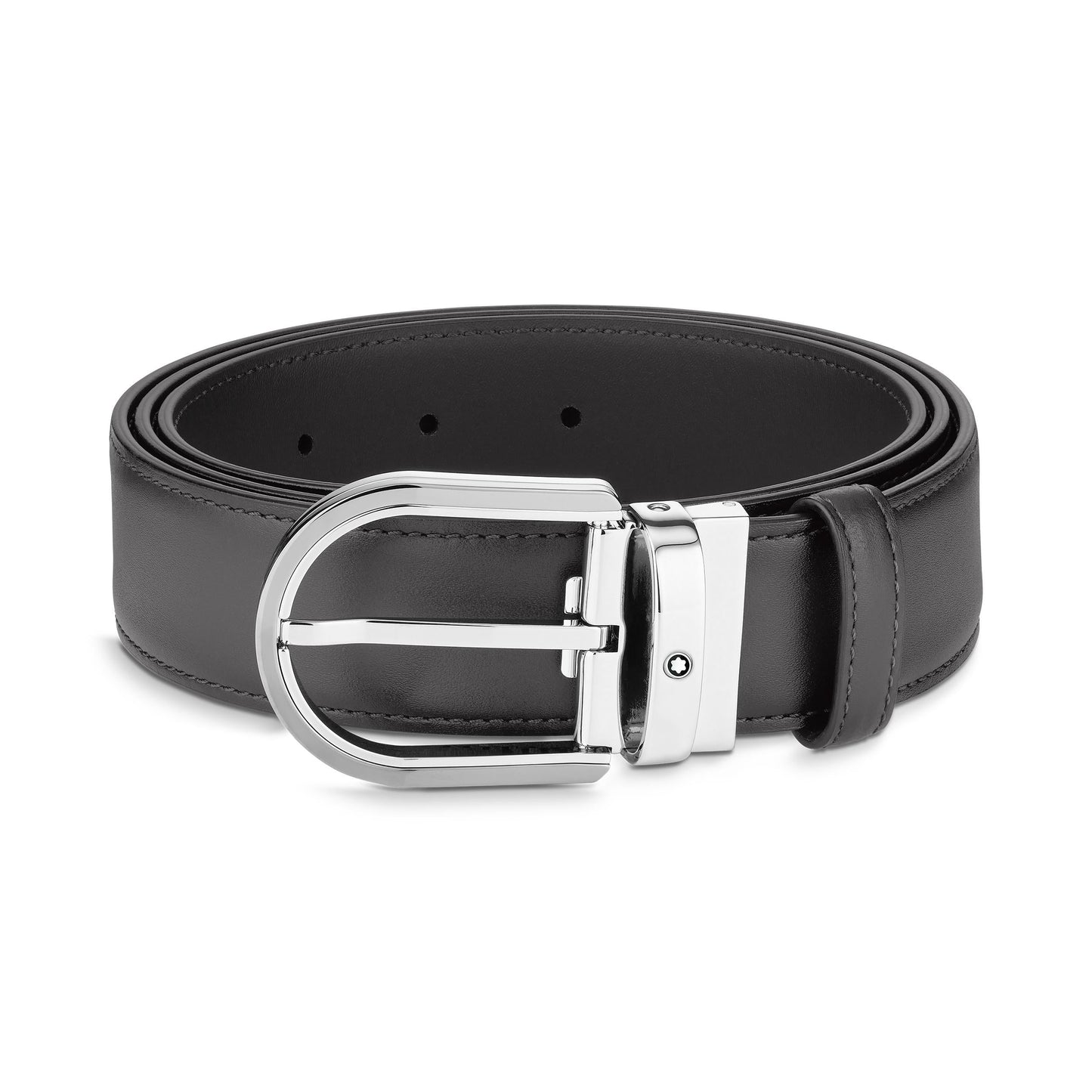The Montblanc Horseshoe Leather Belt is a rolled-up black leather belt featuring a sleek, modern design that reflects contemporary elegance. It includes several holes for adjustability and comes with a shiny silver horseshoe buckle.