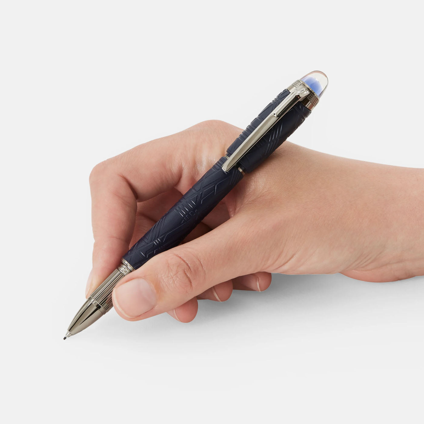 A hand holding a Montblanc Starwalker SpaceBlue Resin Fineliner Pen, enhanced with sleek silver accents, poised for writing against a white background, evokes a sense of futuristic elegance.