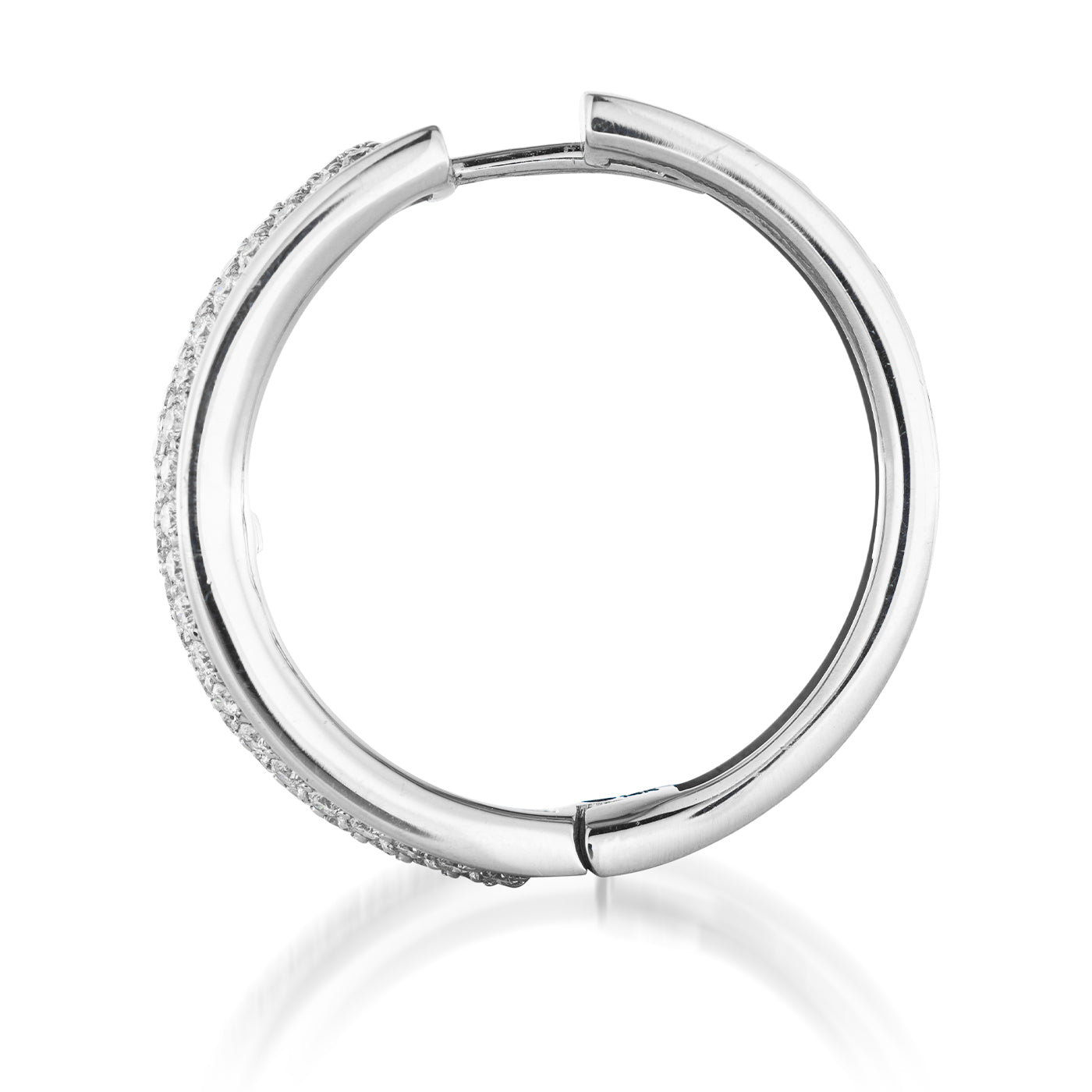 A close-up view of a Raffi&Co.® 14K White Gold Diamond Hoop Earring, adorned with small, pavé-set diamonds. The earring stands elegantly against a white background, its reflection shimmering on the surface below.
