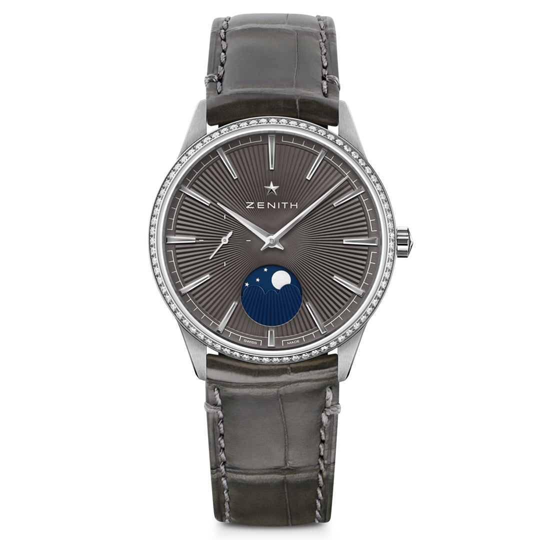 The ZENITH Elite Moonphase Elite 692, by Zenith, features a luxurious design with a grey alligator leather strap and gray dial. It includes a diamond-set silver bezel, silver hour markers, the iconic moon phase at 6 o'clock, and the brand name below the 12 o'clock marker.