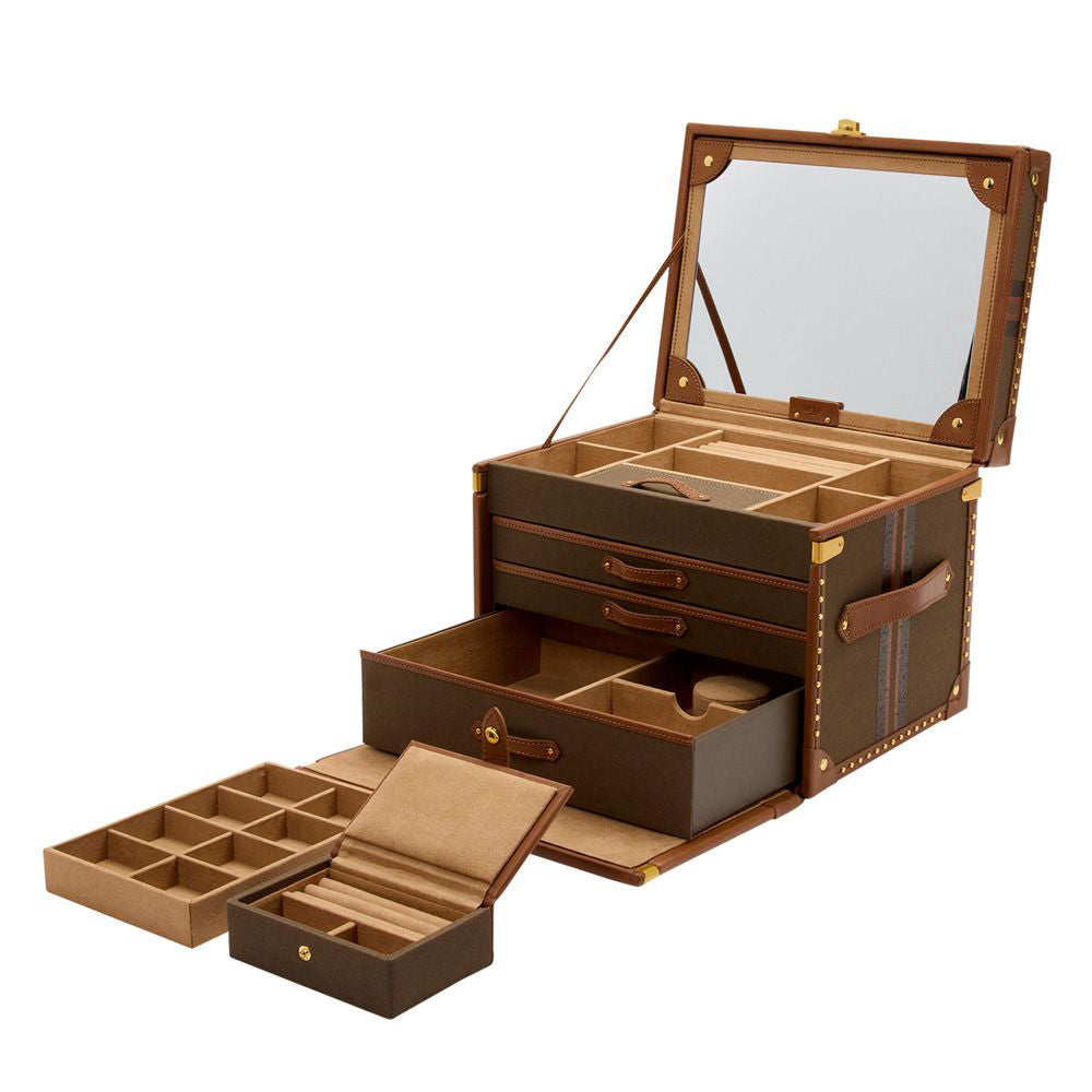 The WOLF 1834 Ida Trunk Jewellery Box, a luxurious open design, showcases elegant brass stud detailing and includes multiple compartments and drawers for optimal jewelry organization. The interior is adorned with soft fabric lining, while the lid features an attached mirror for added convenience. Its custom-designed lock enhances the sophistication of this exquisite piece from WOLF.