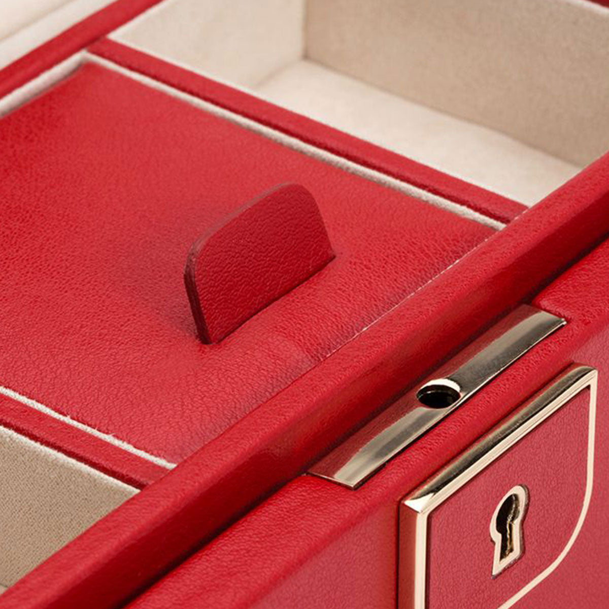 Detailed view of the WOLF 1834 Palermo Small Red Jewellery Box showcasing a gold-toned keyhole. Inside, it features an off-white, anti-tarnish lining and includes a discreet red tab that reveals a hidden compartment.