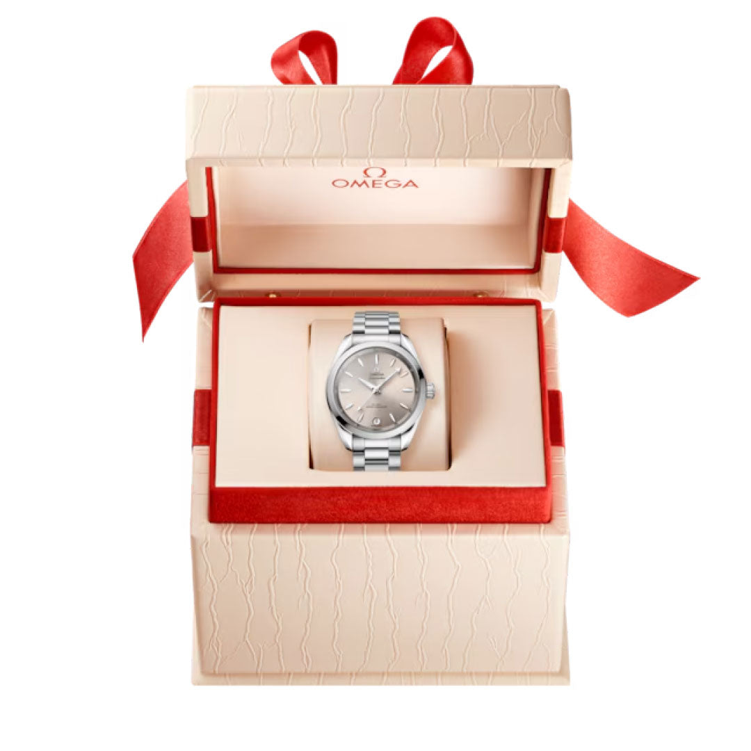 A silver OMEGA Seamaster Aqua Terra Shades Co-Axial Master Chronometer 34mm watch with a metal band is displayed in a cream box with red accents and ribbon, lid open to reveal the OMEGA calibre 8800 inside.