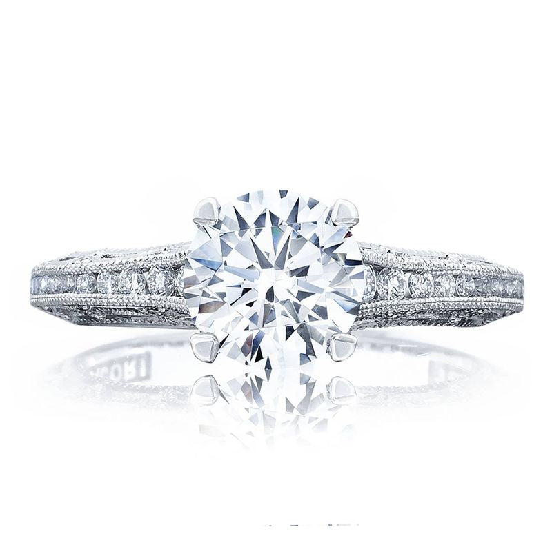The Tacori Reverse Crescent 18K White Gold Round Brilliant Semi Mount Engagement Ring with Diamond Band showcases an elegant design. It features a large central round diamond and a detailed band adorned with smaller diamonds, reflecting the sophisticated design and expert craftsmanship enhanced by Tacori gemologists. The polished finish of the band further highlights its refined aesthetic.