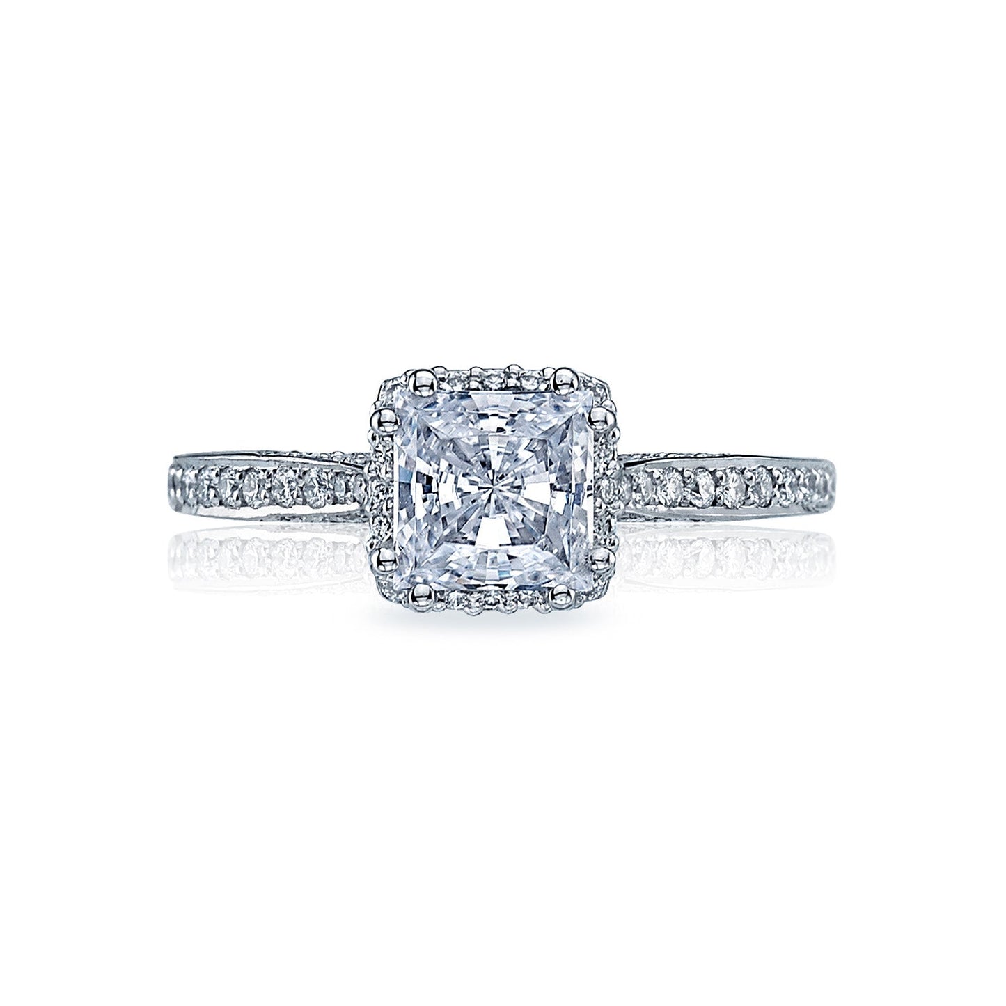 This stunning Tacori Dantela 18K White Gold Engagement Ring showcases a princess cut diamond at its center, enhanced by the artistry of TACORI gemologists. The ring features a diamond band and a hidden halo, elegantly presented against a pristine white background.