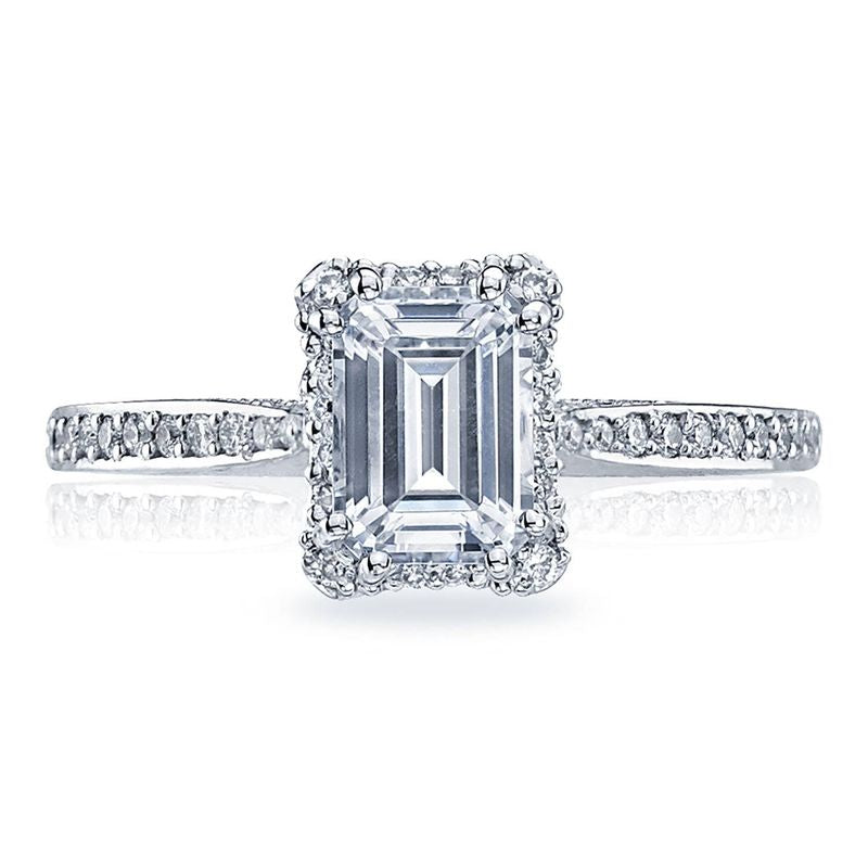 This beautiful Tacori Dantela 18K White Gold Emerald Semi Mount Engagement Ring features an emerald-cut centerpiece, enhanced by a hidden halo of smaller diamonds. The elegant band sparkles with additional diamonds, all set in radiant white gold, highlighting the exquisite craftsmanship of Tacori gemologists.