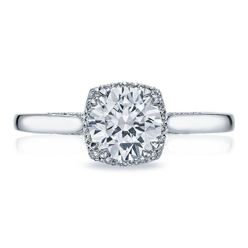 The Tacori Dantela engagement ring showcases a round brilliant diamond centered in 18K white gold, highlighted by a subtle hidden halo of smaller diamonds. The band offers a sleek and polished finish for an elegant touch.