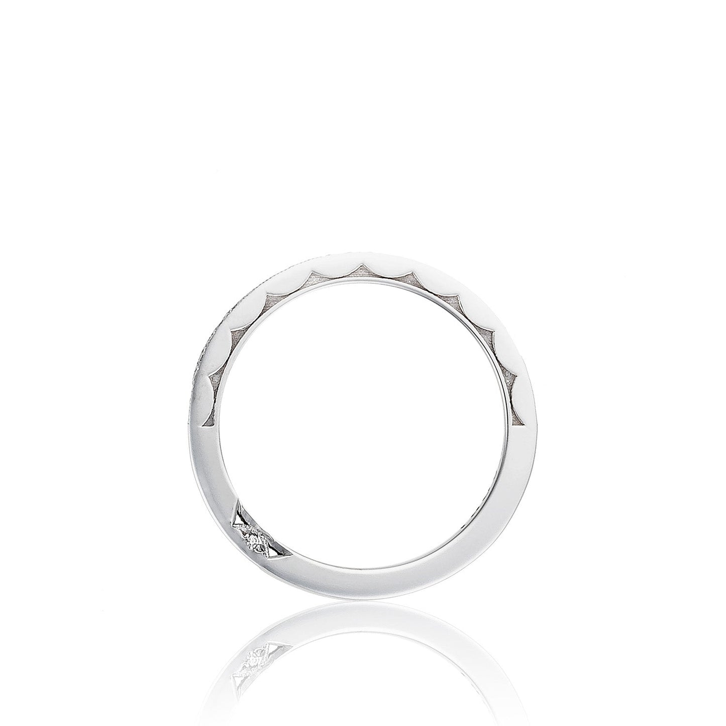 The Tacori Sculpted Crescent 18K White Gold Pavé Round Brilliant Diamond Anniversary Ring showcases a sleek, thin silver band with a distinctive scalloped edge design on the upper half and a small diamond accent on the bottom. Its classic engagement ring style is beautifully highlighted against a white background with subtle reflections.