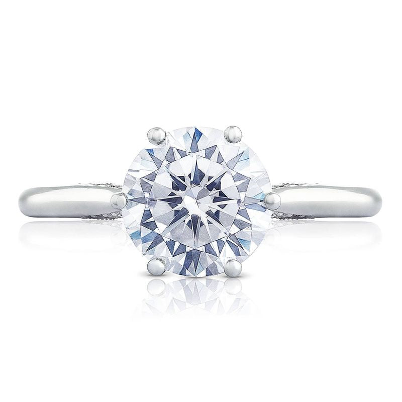 This Tacori Simply engagement ring showcases an 18K white gold band with a round brilliant semi mount solitaire diamond in a prong setting, enhancing its light-reflecting properties and highlighting intricate facets.