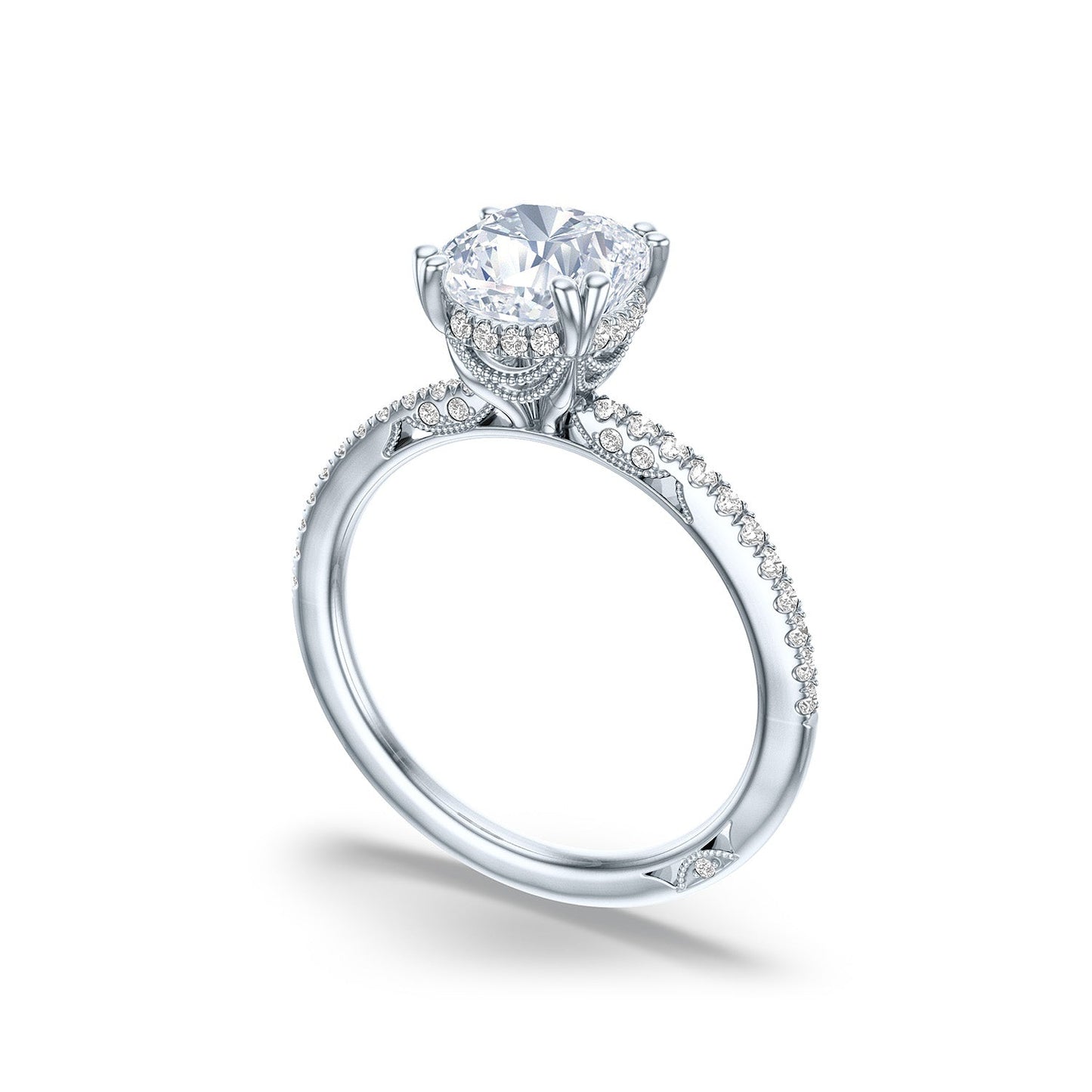 The Tacori Simply 18K White Gold Cushion Semi Mount with Diamond Band and Hidden Halo Engagement Ring presents an elegant and intricate design. Crafted in white gold, it features a large central gemstone in a raised setting, complemented by pavé diamonds for extra sparkle. The piece reflects exquisite bridal details synonymous with the renowned Tacori brand.