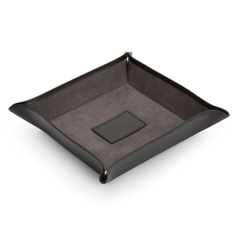 Introducing the WOLF 1834 Blake Coin Tray by WOLF, a sophisticated black leather tray with raised edges and an ultrasuede lining. It's perfect for organizing personal items, featuring a small rectangular patch in the center that seamlessly merges functionality with elegance.