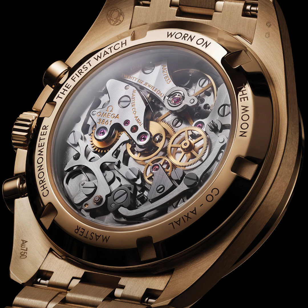 Close-up of the OMEGA Speedmaster Moonwatch Professional Co-Axial Master Chronometer Chronograph 42mm, showing its mechanical gears through a transparent case and an engraved 18K Moonshine™ Gold back honoring the iconic model's moon landing legacy.