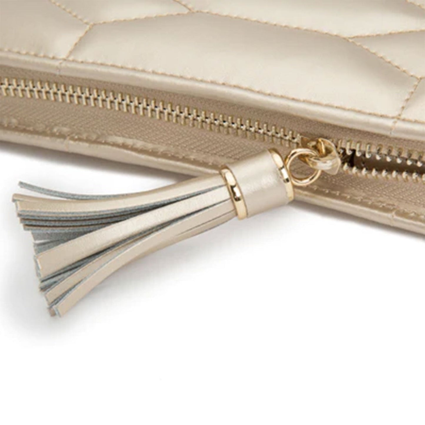 A close-up of the WOLF 1834 Caroline Jewellery Portfolio reveals its elegant beige diamond quilted leather design, complemented by a gold zipper and a decorative tassel. The tassel, attached to the zipper pull, features multiple strands in neutral tones, adding an elegance reminiscent of fine jewelry collections.
