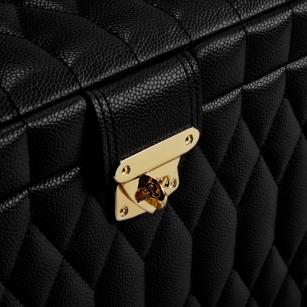 Close-up of the WOLF 1834 Lauren Large Jewellery Box in black, featuring a diamond-quilted leather exterior with a textured finish and a shiny, tarnish-resistant gold clasp on the front.
