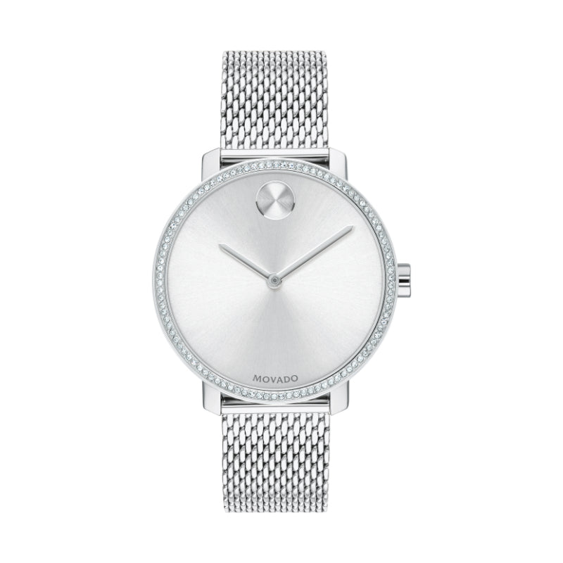 The Movado BOLD Shimmer Quartz 34mm Watch showcases a minimalist design with a mesh metal strap and silver dial. The minimal hour markers are accentuated by the iconic dot at the 12 o'clock position. Its stainless steel case, complemented by a crystal pave bezel, enhances the elegance and sophistication typical of the Movado brand.