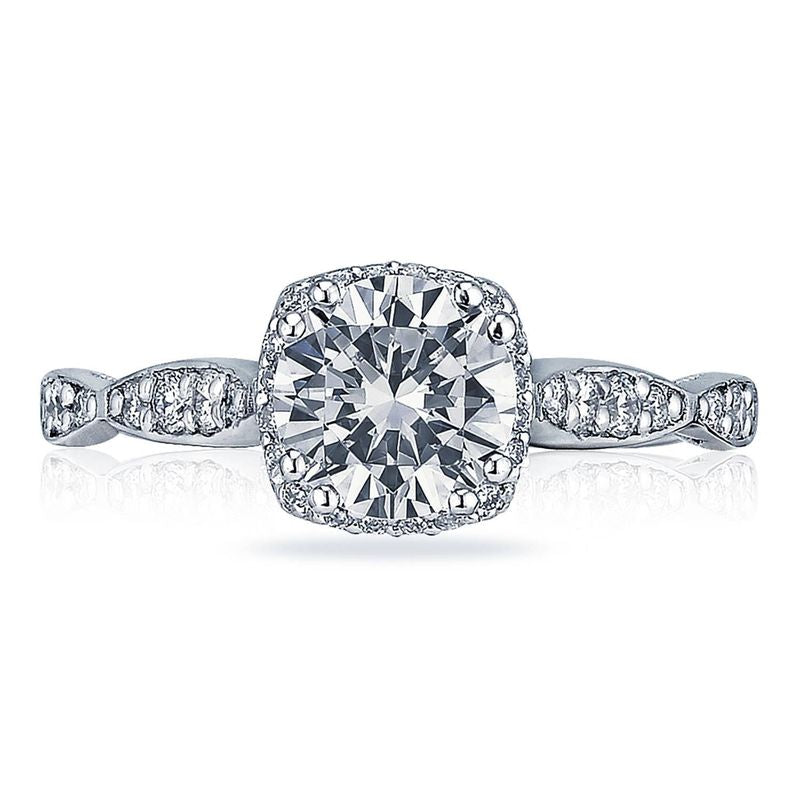 Discover the captivating beauty of the Tacori Dantela Platinum Cushion Semi Mount Engagement Ring, highlighted by a large, central diamond framed by a sparkling halo of diamonds. The band artfully combines gleaming diamond accents with intricately twisted metal segments, showcasing the expert craftsmanship of Tacori gemologists.