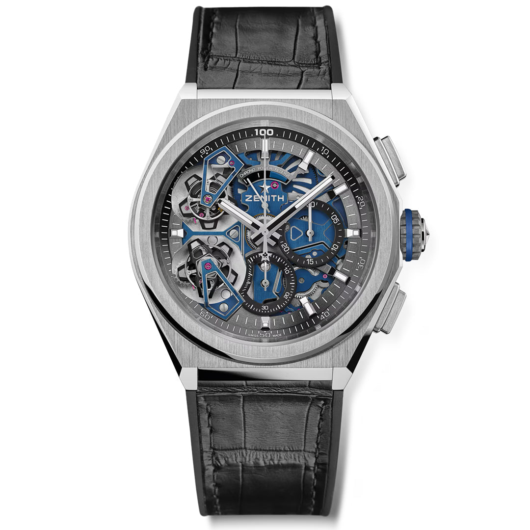 The Zenith ZENITH Defy Double Tourbillon El Primero 9020 46mm Watch features a platinum case with a black leather strap. Its blue and silver skeleton dial reveals internal mechanics, complemented by three sub-dials, including a 1/100th second chronograph and a prominent right-side crown.