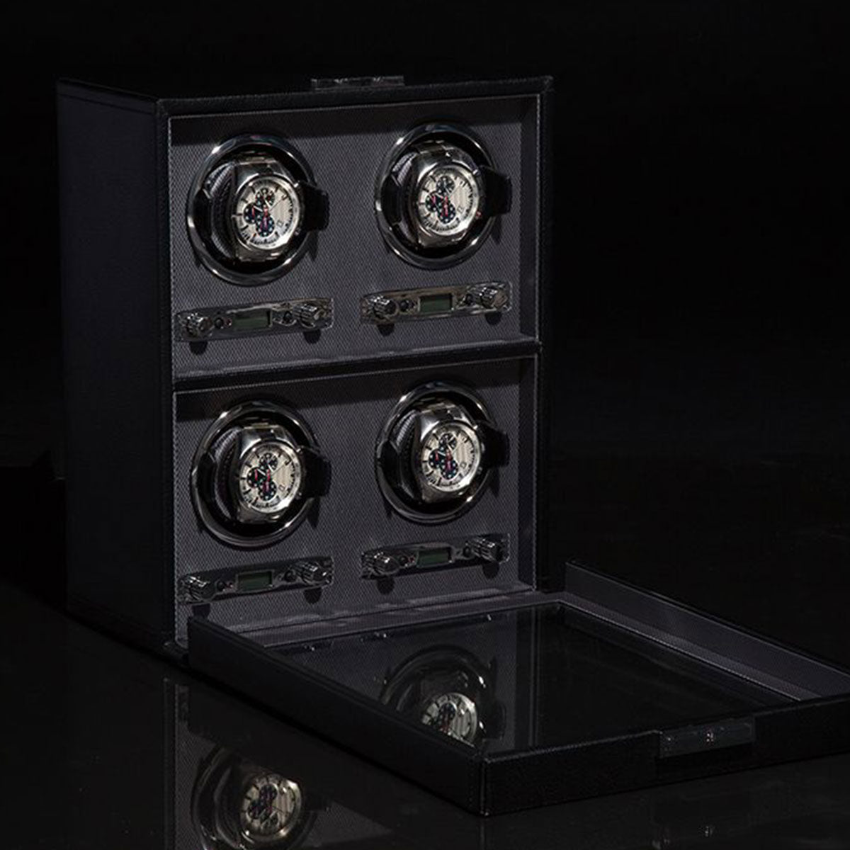 The WOLF 1834 Viceroy Black Watch Winder, featuring a glass lid, offers slots for four watches. Two timepieces are prominently displayed while two slots are unoccupied. Its modern classic design is highlighted by a glossy surface set against a dark background.
