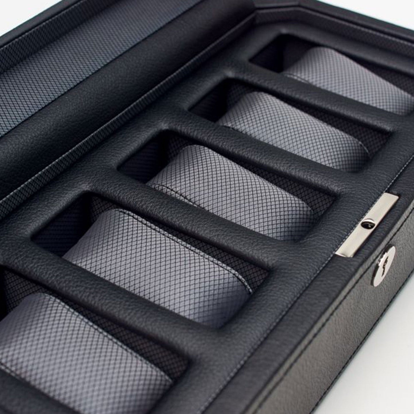 A sleek WOLF 1834 Windsor 5 Piece Watch Box, crafted from black vegan leather, neatly stores five rolled-up, textured gray ties. Each tie is organized in an individual compartment, with a metal lock securing the stylish case from WOLF.