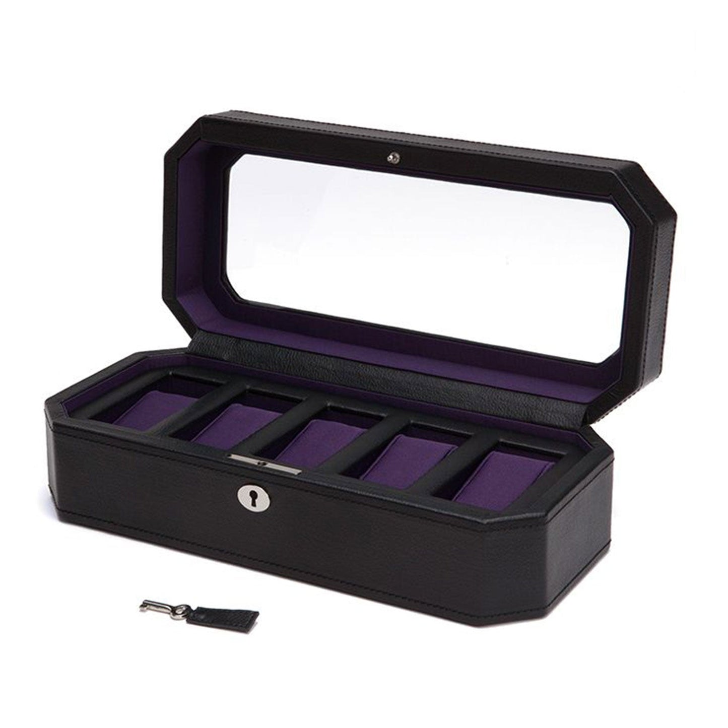 The WOLF 1834 Windsor 5 Piece Watch Box features a vegan leather exterior and a transparent lid, which opens to reveal five compartments lined with purple fabric. In front of this elegant watch storage solution is a small silver lock and matching key with a black tag, offering both style and organization.