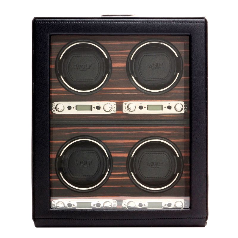Introducing the WOLF 1834 Roadster 4 Piece Winder, a sophisticated black leather watch accessory from the renowned brand WOLF. This winder features four circular mounts for your timepieces, each adorned with a digital display set against an elegant Ebony Macassar wood grain backdrop, perfectly blending style and functionality.