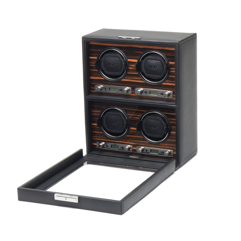 The WOLF 1834 Roadster 4 Piece Winder from WOLF is a sleek black leather watch winder with an Ebony Macassar interior. It includes four slots, each equipped with individual control panels. The open front panel showcases the slots and controls, offering a seamless blend of style and functionality for any watch enthusiast.