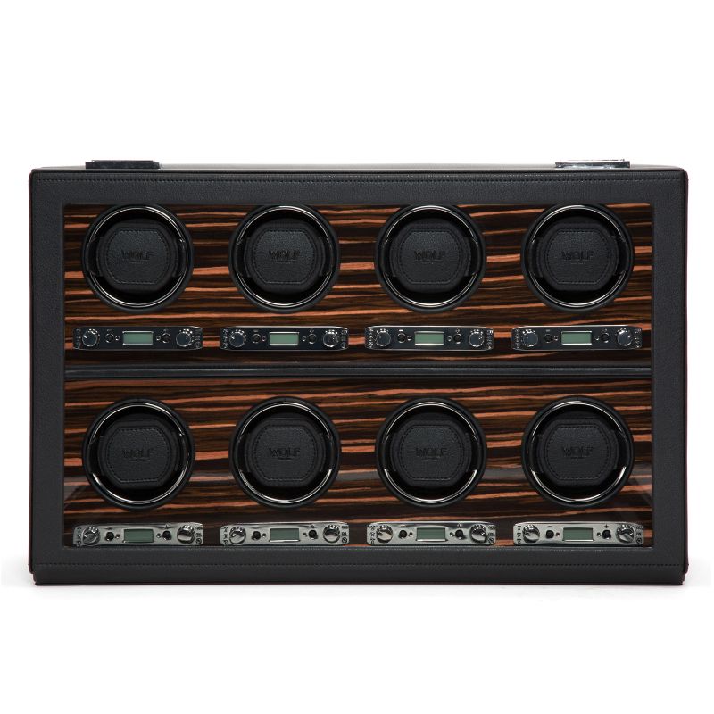 The WOLF 1834 Roadster 8 Piece Winder features a rectangular panel displaying eight circular dials in two neat rows of four, all set against a luxurious ebony macassar background. It includes small digital displays and control knobs below each dial, creating a sophisticated design that functions as an elegant watch winder with bi-directional settings.