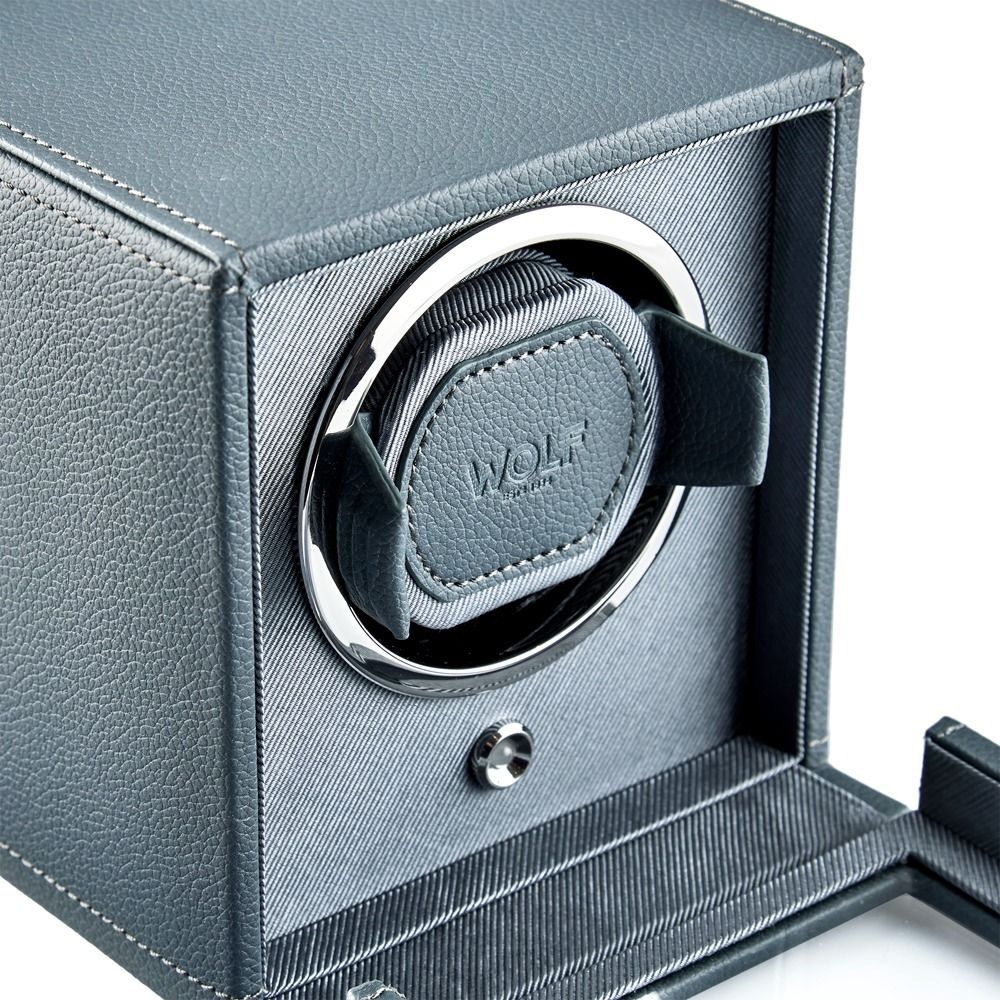 Close-up of the WOLF 1834 Cub Single Watch Winder in grey, featuring vegan leather with textured material, visible stitching detail, a circular opening with chrome trim, and a cushioned holder for your watch. The front panel is open to highlight the craftsmanship.
