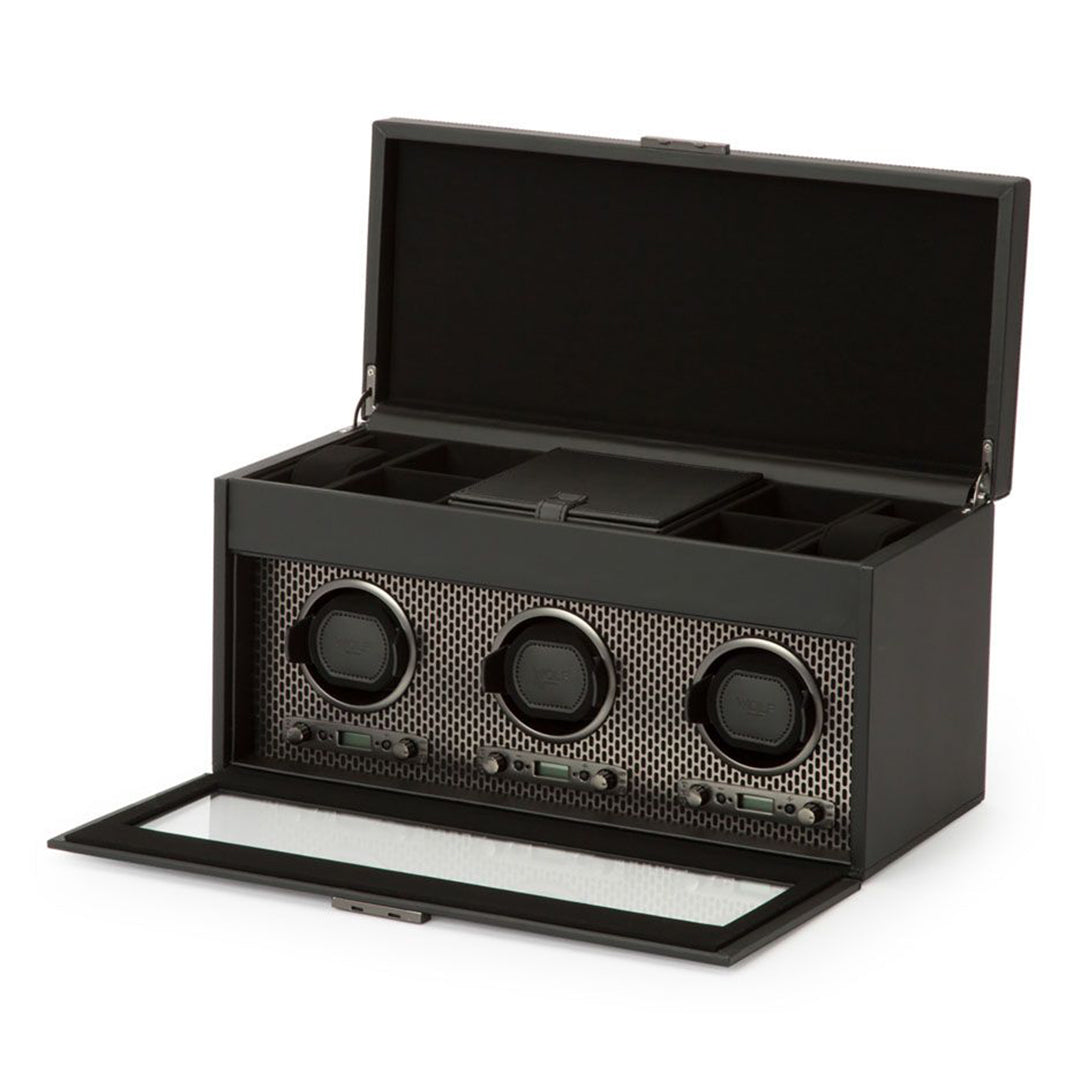 Presenting the WOLF 1834 Axis Triple Watch Winder With Storage, this elegant piece features a sleek black design paired with a textured vegan leather interior. Its three-slot capacity is beautifully displayed through the open box and front glass panel, ideal for showcasing your prized watches. Equipped with multiple rotation settings, it guarantees that your timepieces are meticulously maintained and always ready to wear.