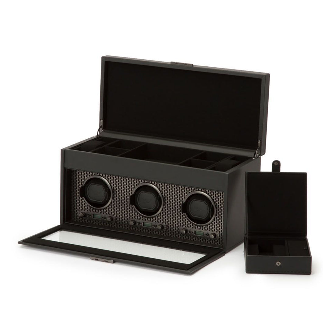 Introducing the WOLF 1834 Axis Triple Watch Winder With Storage, a sophisticated piece designed by WOLF. This sleek winder, crafted from vegan leather in a classic black finish, features an open lid that unveils three circular compartments for your watches. It offers multiple rotation settings and includes a removable storage section for small items, enhancing its functional yet elegant design.