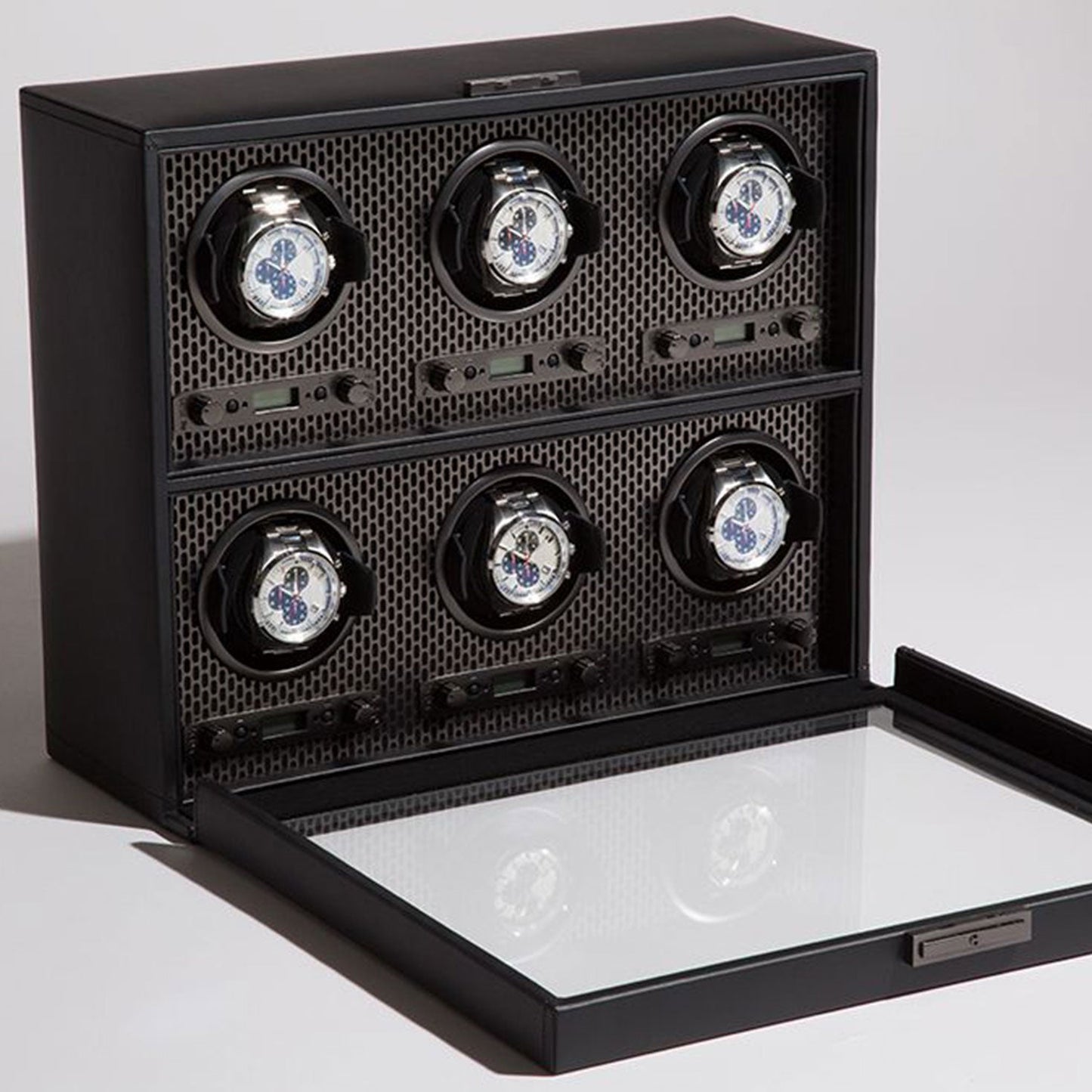 The WOLF 1834 Axis Watch Winder by WOLF features a modern luxury design with a glass lid and six slots, each equipped with a black holder that beautifully showcases a white watch face against a textured background. The open lid elegantly displays your collection, while its patented technology ensures optimal performance.