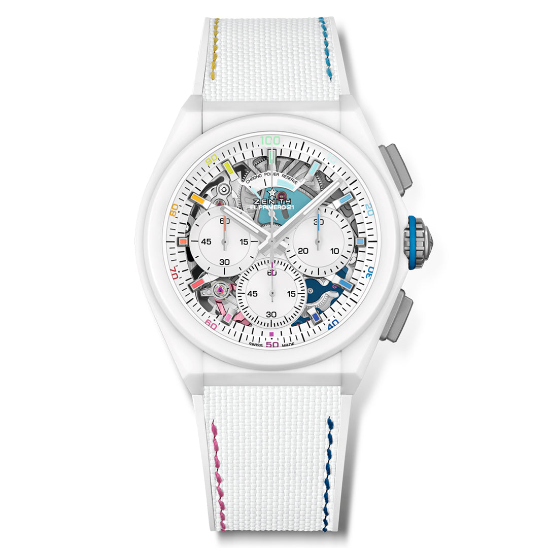 The ZENITH Defy El Primero 21 is a limited edition watch featuring a transparent dial showing its inner gears, enclosed in a sleek white ceramic case. This Zenith timepiece has a white strap with colorful stitching and visible numerals and hands, plus subdials akin to the El Primero chronograph style.
