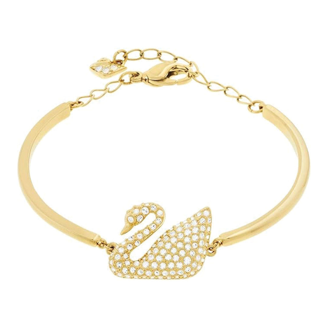 Introducing the Swarovski Swan Bangle, a breathtaking gold bracelet from Swarovski that highlights a rhodium-plated swan design. It is embellished with small, dazzling crystals and features an adjustable chain with a charming heart-shaped charm near the clasp for an added touch of elegance.