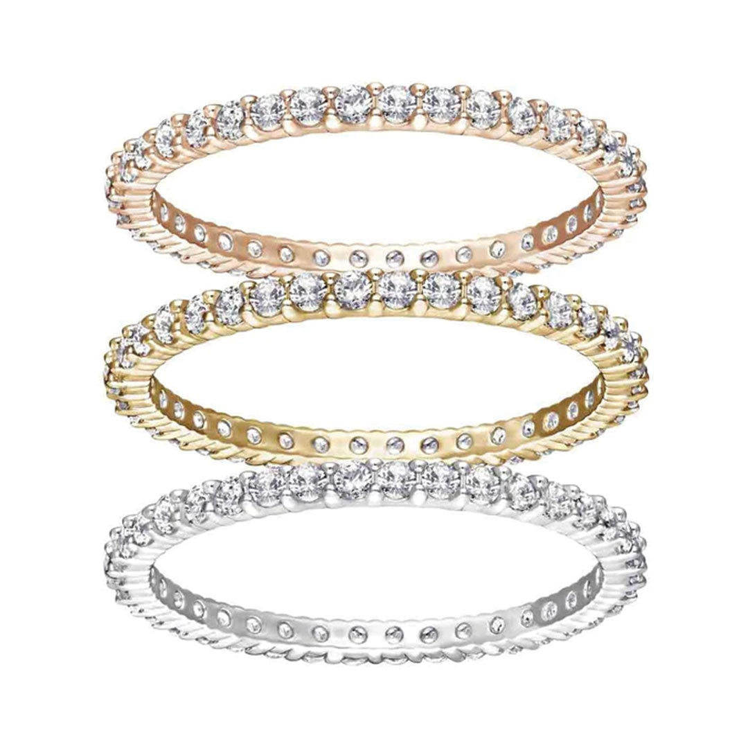 The Swarovski Vittore Tri-Colour Three Rings Set features a stunning trio of eternity rings stacked vertically, crafted in rose gold, yellow gold, and white gold. Each exquisite piece from Swarovski is adorned with a continuous circle of small, sparkling diamonds, creating an elegant and timeless look.