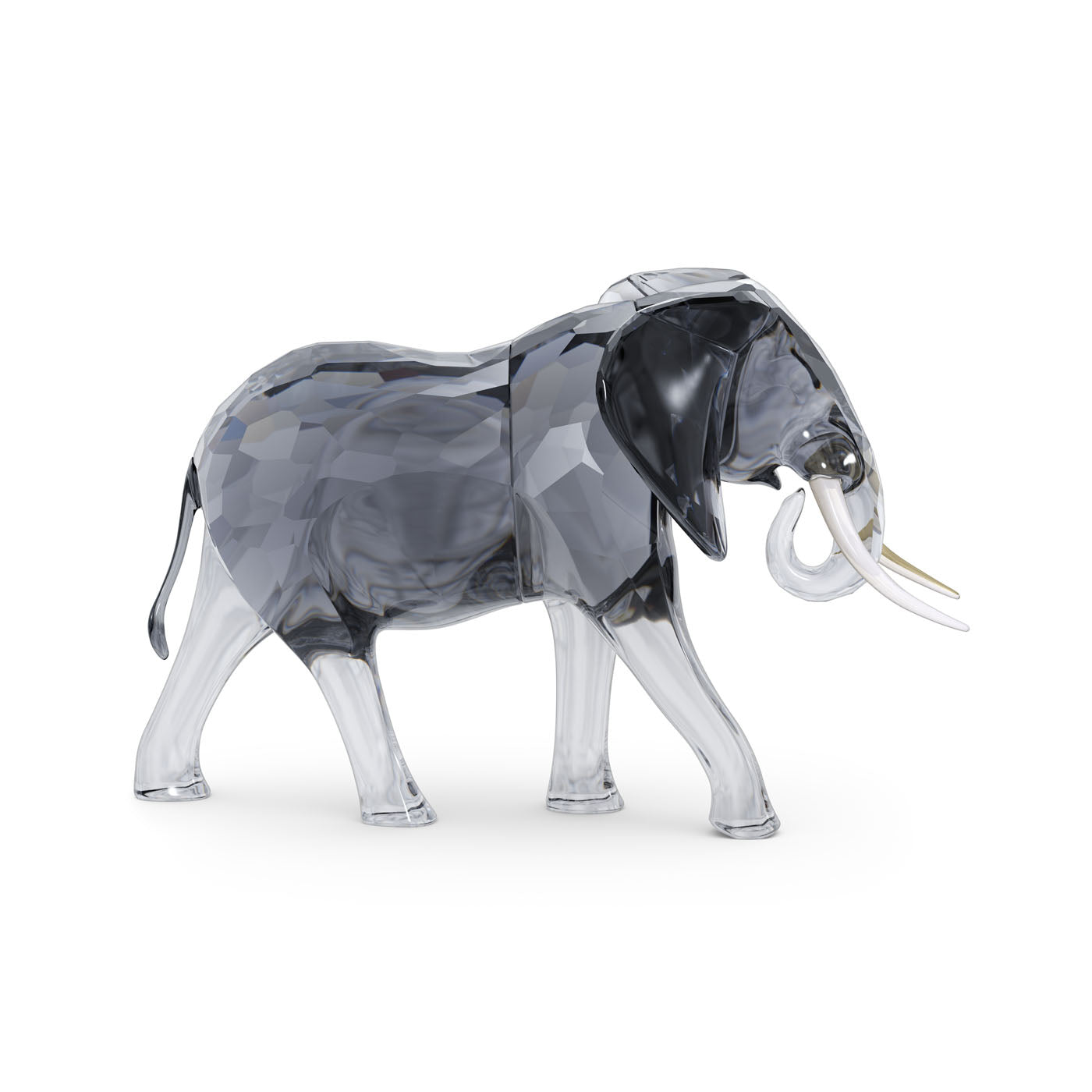 This exquisite Swarovski Elegance of Africa Elephant Bull Crystal Home Décor piece is meticulously crafted from clear and dark gray faceted glass, highlighting intricate details and featuring a shiny, reflective surface. Adorned with white tusks, it beautifully captures the subtle allure of African wildlife against a plain white background.